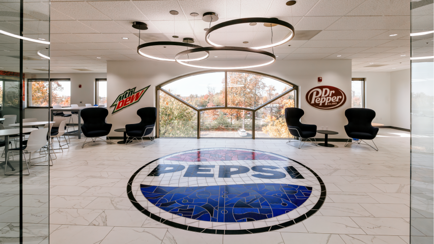 Photo of corporate entry way depicting Pepsi logo on the floor and Dr Pepper / Mtn Dew on the back walls