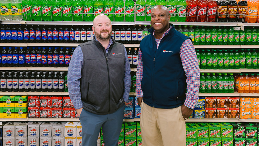 2 men standing in front of Pepsi products displayed in the store
