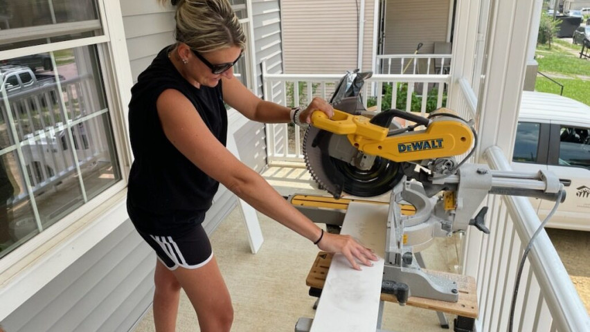 woman with circular saw on a porch