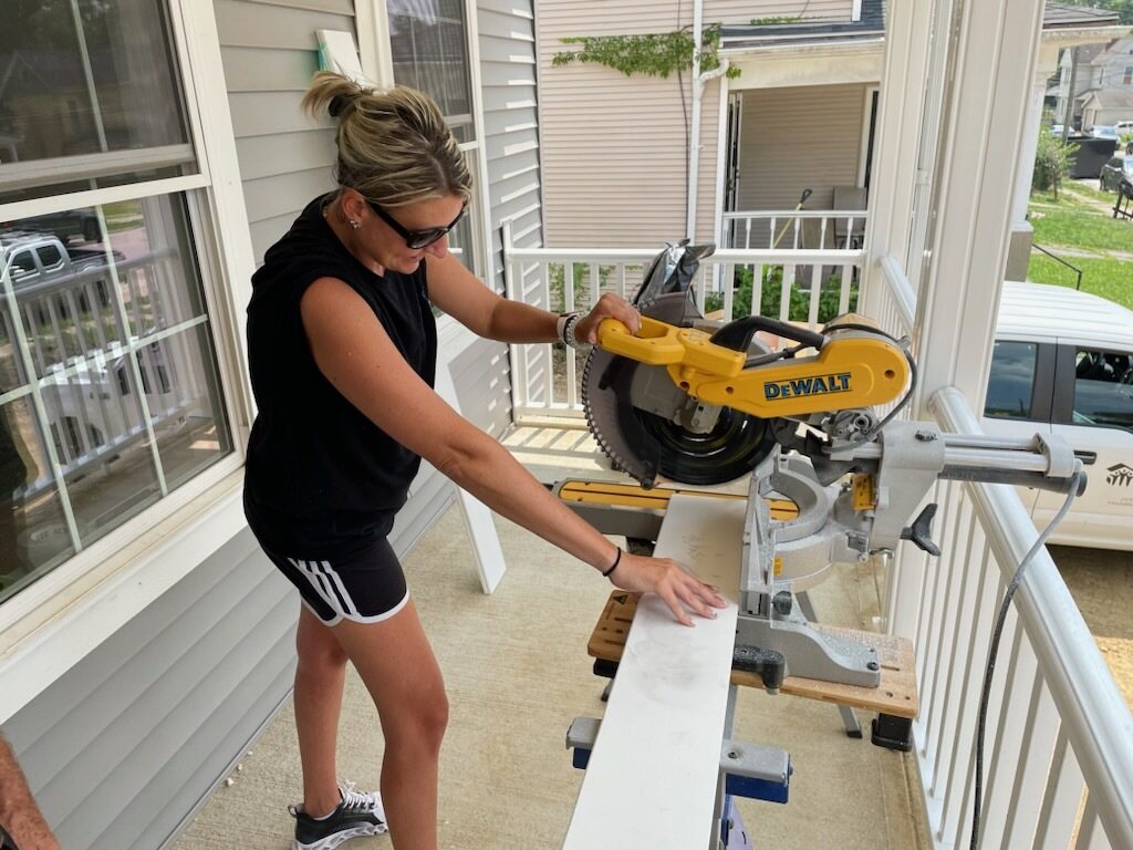 woman with circular saw on a porch